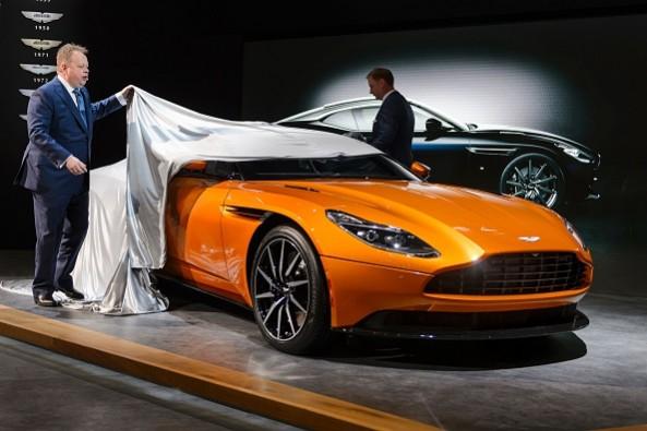 Aston Martin CEO Andy Palmer shows the new DB11 model car at the stand of the British carmaker during the press day of the Geneva Motor Show on March 1, 2016 in Geneva. Aston Martin