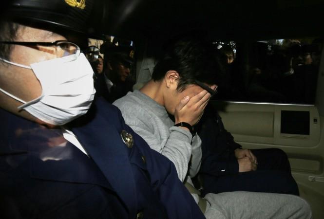 Takahiro Shiraishi (C) covers his face with his hands as he is transported to the prosecutor's office from a police station in Tokyo. Takahiro Shiraishi