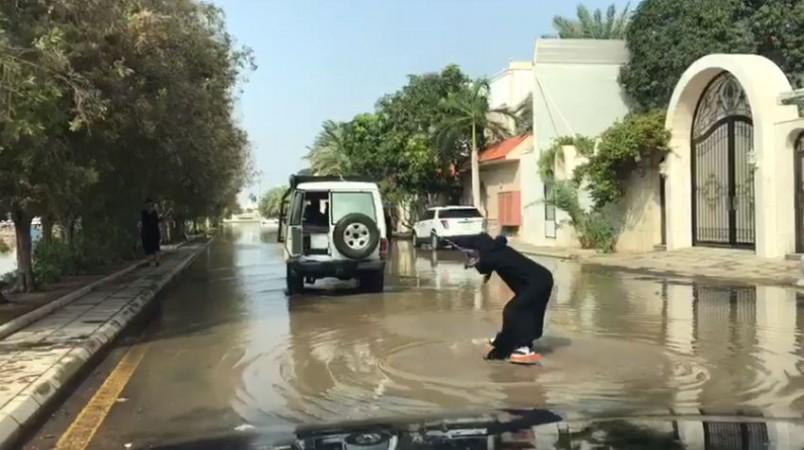 An unknown woman is seen surfing in flood waters in Jeddah Saudi woman surfing