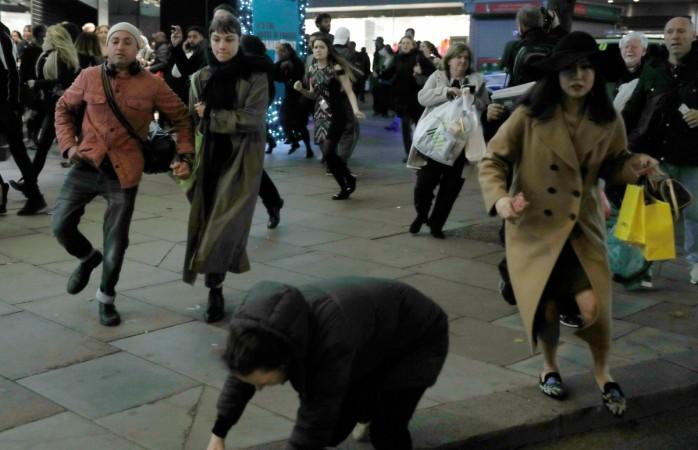 A woman stumbes as people run down Oxford Street, London, Britain November 24, 2017 Oxford Street