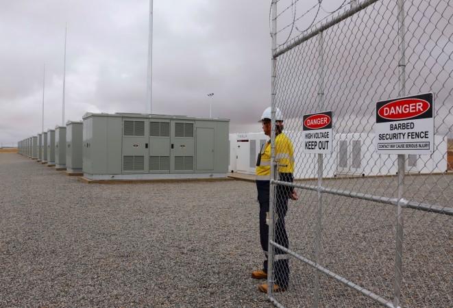 A worker stands at the main gate for the compound housing the Hornsdale Power Reserve, featuring the world's largest lithium ion battery made by Tesla, during the official launch near the South Australian town of Jamestown, in Australia, December 1, 2017. Tesla world's largest li-ion battery