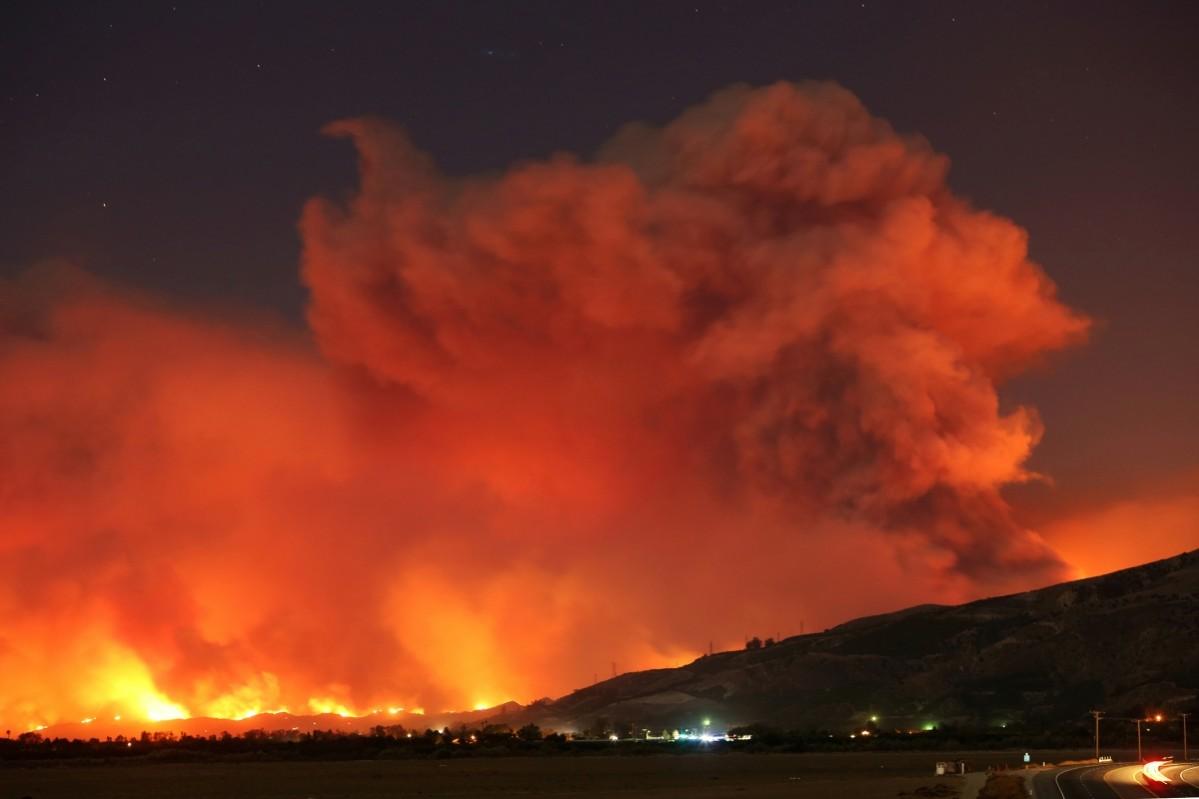 Smoke rises into the night sky as strong winds push the Thomas Fire across thousands of acres near Santa Paula, California, U.S., December 4, 2017. California wildfire