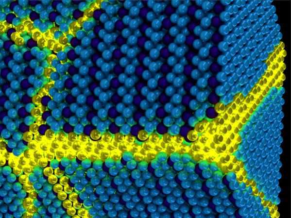 Artist's depiction of the collective excitons of an excitonic solid. These excitations can be thought of as propagating domain walls (yellow) in an otherwise ordered solid exciton background (blue). Excitonium