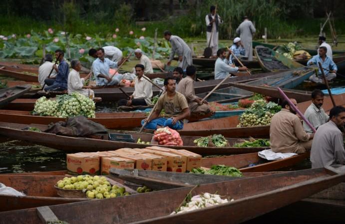 Kashmiri Muslims gather with their boats laden with vegetables at the floating vegetable market on Dal Lake at dawn in Srinagar Floating market