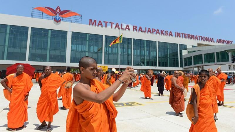 A Sri Lankan Buddhist monk takes pictures of an unseen Sri Lankan airlines Airbus A-340 at the Mattala Rajapaksa International Airport Mattala Rajapaksa International Airport
