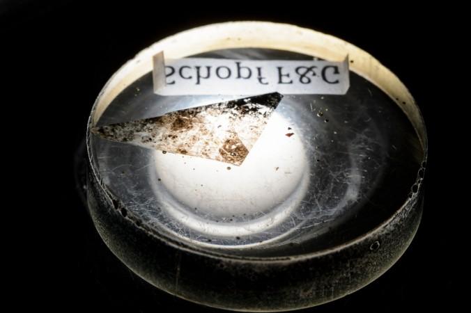 An epoxy mount containing a sliver of a nearly 3.5 billion-year-old rock from the Apex chert deposit in Western Australia is pictured at the Wisconsin Secondary Ion Mass Spectrometer Lab (WiscSIMS) in Weeks Hall. Ancient fossils discovered