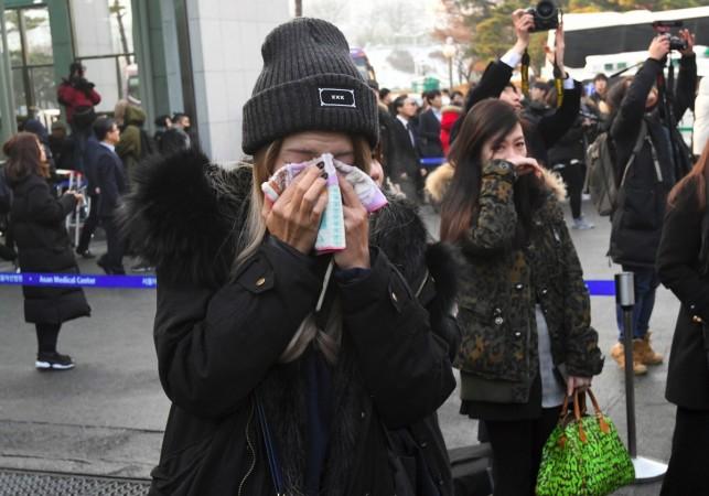 Fans of late SHINee singer Kim Jong-Hyun cry as the hearse carrying the body of Kim Jong-Hyun leaves from a hospital in Seoul on December 21, 2017. Kim Jonghyun body