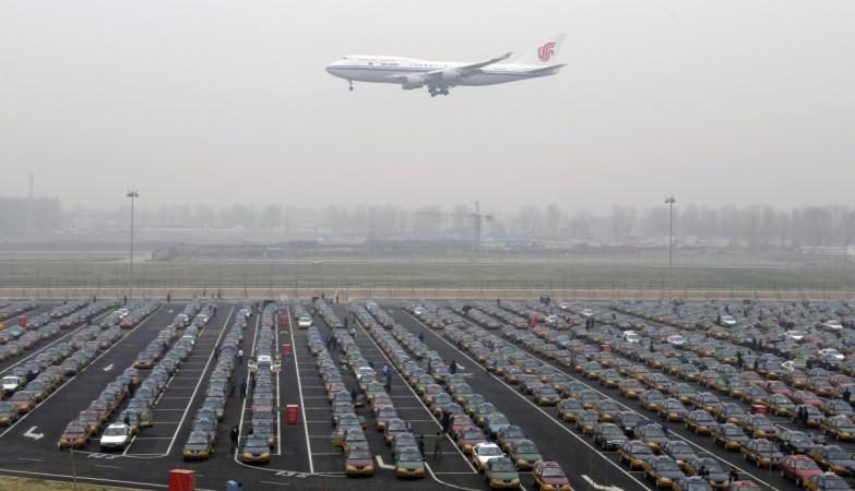An Air China jetliner descends to land past rows and rows of taxis waiting at the new airport terminal in Beijing on April 6, 2008. Air China