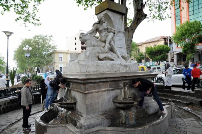 A picture taken on May 6, 2012 shows Algerians drinking from the fountain of Ain El Fouara in Setif, somme 300 kilometres east of the capital. According to the police, a man with mental disabilities vandalised the fountain of Ain El Fouara on December 18, 2017. Algeria Ain El Fouara naked statue