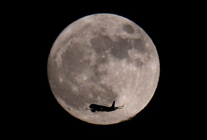 A passenger plane, with a 'supermoon' full moon seen behind, makes its final landing approach towards Heathrow Airport in London, Britain, January 1, 2018. Supermoon 2018