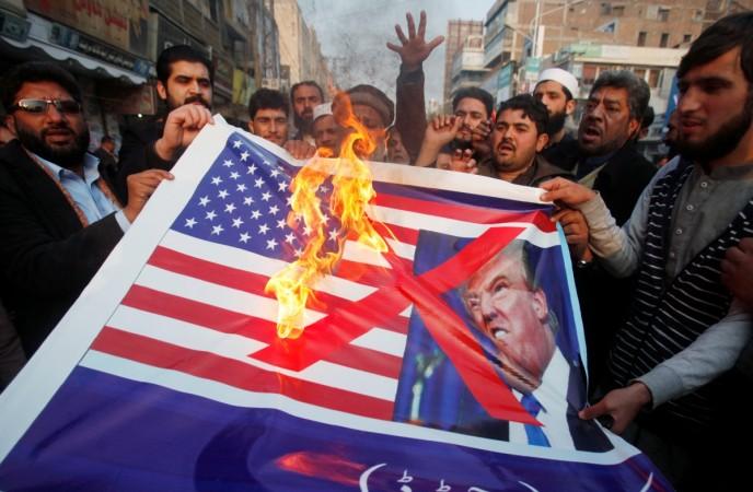 People burn a sign depicting a U.S. flag and a picture of U.S. President Donald Trump as they take part in an anti-U.S. rally in Peshawar, Pakistan, January 5, 2018. Pakistan