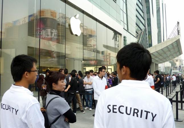 Chinese security personnel on standby as people queue for the launch of the iPhone 4 outside Apple's flagship store in Beijing on September 25, 2010. Apple launched the latest version of its iPhone in China and boosted its presence in the world's biggest Internet and mobile market by opening another two stores in Beijing and Shanghai. Chinese security personnel on standby as