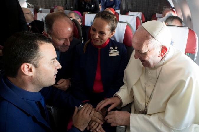 Pope Francis celebrates the marriage of crew members Paula Podest (C) and Carlos Ciufffardi (L) during the flight between Santiago and the northern city of Iquique, Chile January 18, 2018. Pope Francis performs marriage ceremony