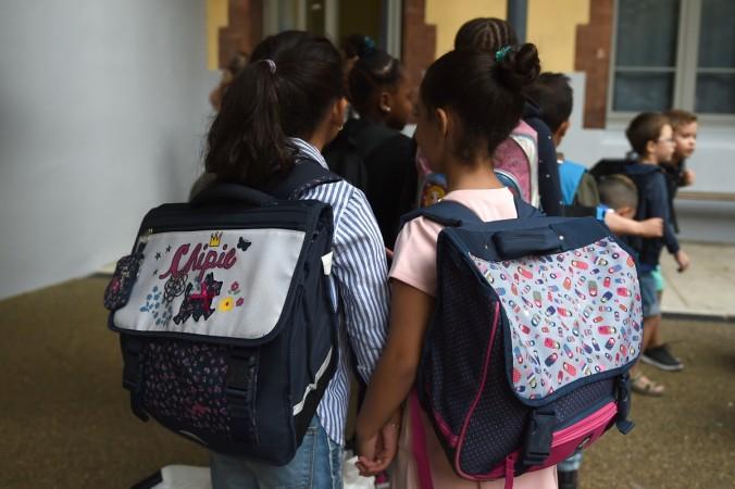 Pupils enter their classroom in the Francois Masson primary school on the first day of the new school year on September 4, 2017, in Marseille, southern France. Schoolbags
