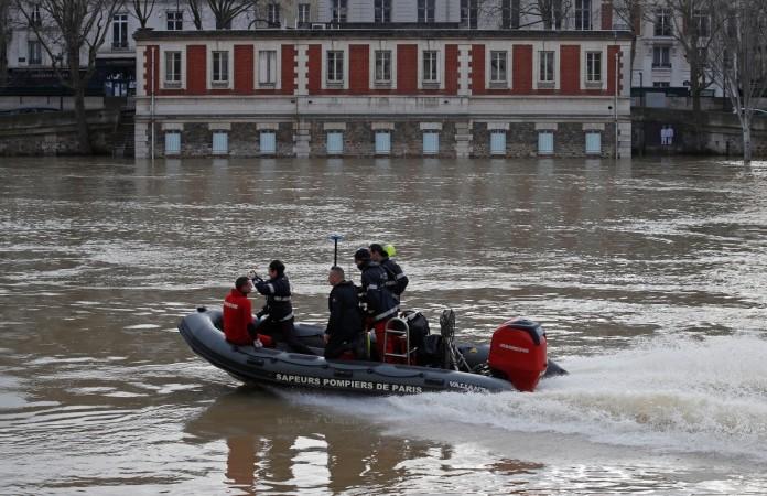 Paris fire-brigade divers on a small boat patrol the flooded Seine River, France, after days of almost non-stop rain caused flooding in the country, January 24, 2018. Paris flood