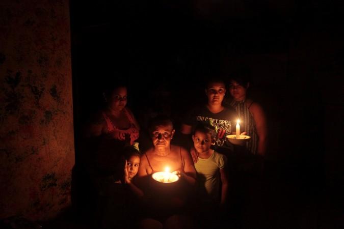 A family poses with candles in the darkness of their home after Hurricane Maria hit the island and damaged the power grid in September, in Vega Alta, Puerto Rico puerto rico