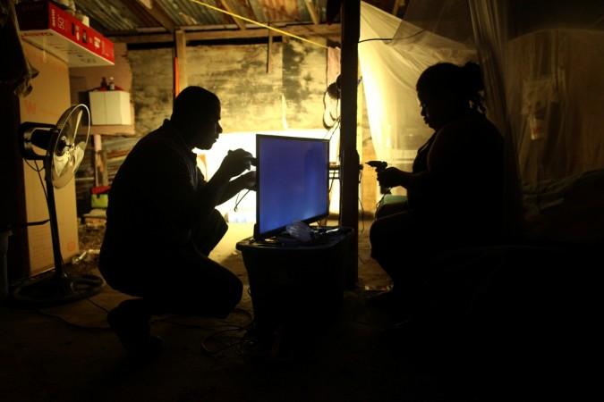 Alberto Julian and his wife Zulma Rodriguez try to fix their television powered with the help of a generator after Hurricane Maria damaged the electrical grid in September, in Dorado, Puerto Rico Puerto Rico