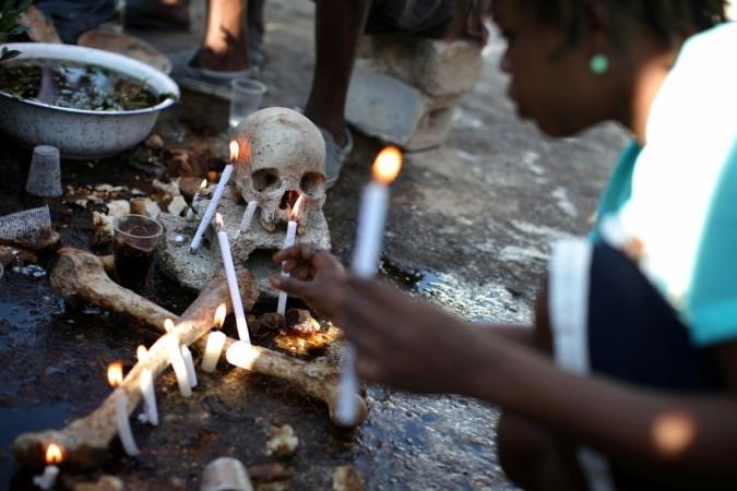 A voodoo believer makes offerings during celebrations at the cemetery of Port-au-Prince, Haiti, November 1, 2017. voodoo