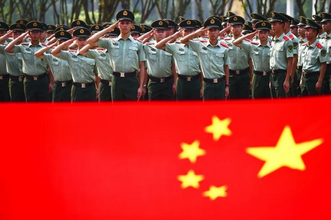 Retiring paramilitary policemen take their oaths in front of a Chinese national flag during their farewell ceremony in Shenzhen, Guangdong province, China September 12, 2017. Picture taken September 12, 2017. Retiring paramilitary policemen take their oaths in front of a Chinese national flag