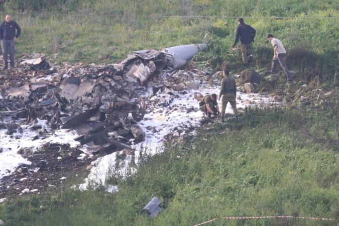 Israeli security forces walk next to the remains of an F-16 Israeli war plane near the Israeli village of Harduf, Israel February 10, 2018 F-16 Israeli war plane