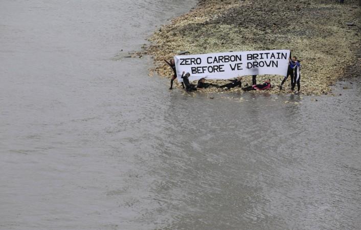 Environmental activists hold a banner which reads London