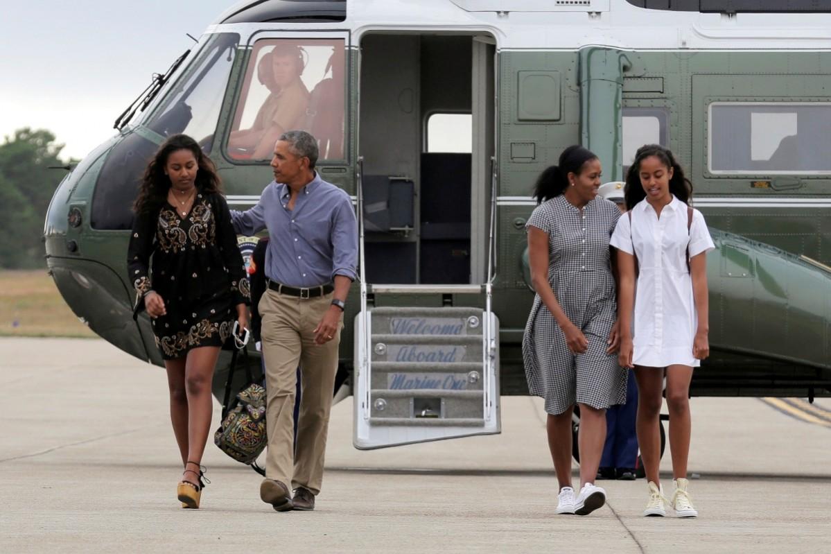 Barack Obama, Michelle Obama and their daughters Malia (R) and Sasha (L) board Air Force One at Cape Cod Coast Guard Air Station in Buzzards Bay, Massachusetts, US, August 21, 2016. Barack and Michelle Obama