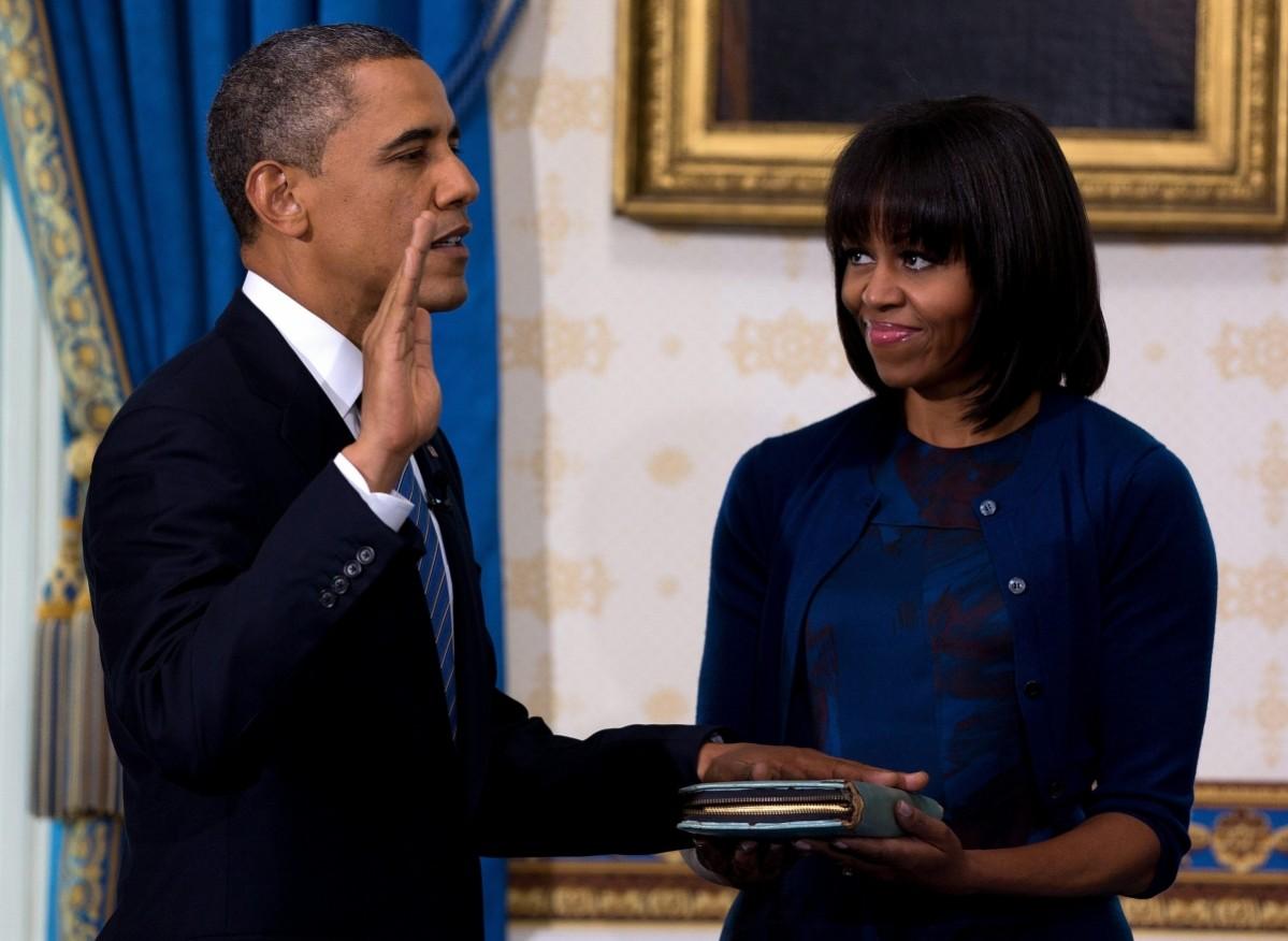 Barack Obama takes the oath of office as Michelle Obama holds a bible during the official swearing-in ceremony at the White House in Washington January 20, 2013. Barack and Michelle Obama