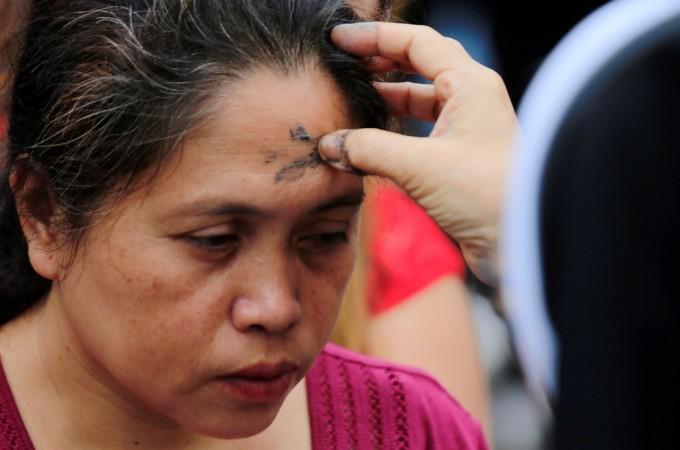 A Catholic nun marks a cross on the forehead of a devotee using ash during the observance of Ash Wednesday, which marks the start of Lent, at a National Shrine of Our Mother of Perpetual Help in Paranaque city, Metro Manila, Philippines February 14, 2018. A Catholic nun marks a cross on the forehead of a devotee using ash during the observance of Ash Wednesday