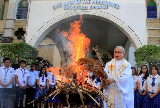 Fr. Jerry Habunal, a Catholic priest, leads the burning dried palm leaves as they burn to be used for Ash Wednesday rites, marking the start of Lent at the Our Lady of the Abandoned Diocesan Shrine Parish in Muntinlupa city, south of Manila, Philippines February 9, 2018. Fr. Jerry Habunal, a Catholic priest, leads the burning dried palm leaves as they burn to be used for Ash Wednesday rites