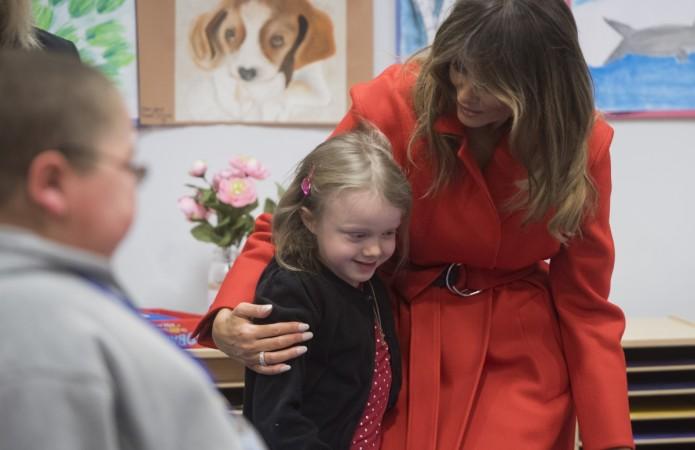 US First Lady Melania Trump hugs a girl as she exchanges valentines for Valentine's Day as she visits with children who are currently patients at the National Institutes of Health (NIH) at The Children's Inn at NIH in Bethesda, Maryland, February 14, 2018. Melania Trump