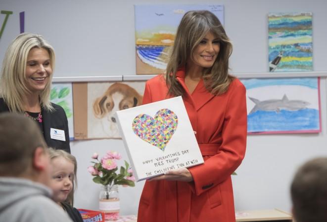 US First Lady Melania Trump holds up a gift as she exchanges valentines for Valentine's Day as she visits with children who are currently patients at the National Institutes of Health (NIH) at The Children's Inn at NIH in Bethesda, Maryland, February 14, 2018. Melania Trump