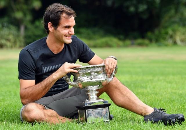 Roger Federer holds the Australia Open trophy at Government House as he poses for pictures following his win in the Australian Open in Melbourne roger federer
