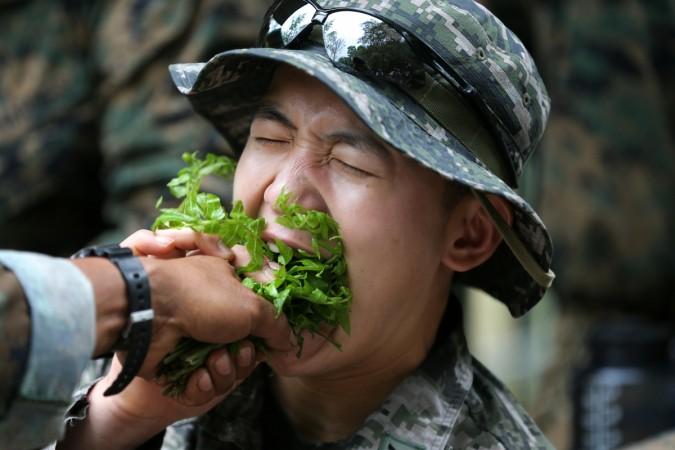 A South Korea marine eats local vegetables during a jungle survival exercise as part of the Us marines