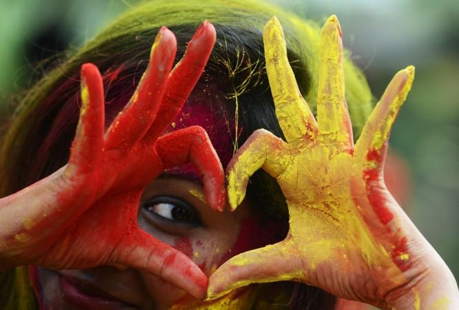Indian students play with coloured powders as they celebrate 'holi' or the 'festival of colours' during a special function in Kolkata on March 12, 2017 Holi 2018