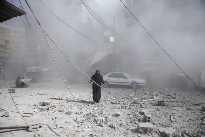 A woman gestures as she walks on rubble of damaged buildings after an airstrike in the besieged town of Douma in eastern Ghouta. syria