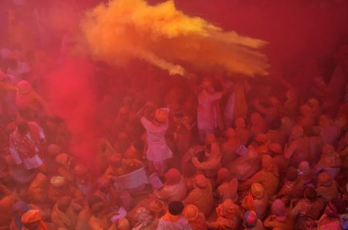 Hindu devotees throw colored powder during celebration of Holi Festival at Sriji temple in Barsana in the northern Indian state of Uttar Pradesh on February 23, 2018. Holi