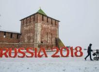 A man pushes a stroler past a FIFA World Cup 2018 emblem placed in front of the Nizhny Novgorod's Kremlin