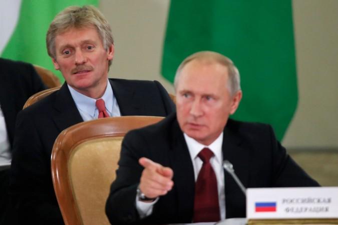 Russia's President Vladimir Putin (front) and Kremlin spokesman Dmitry Peskov attend a session of the Council of Heads of the Commonwealth of Independent States (CIS) in Sochi on October 11, 2017.
