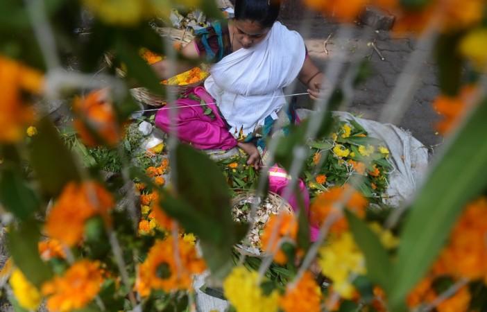 An Indian vendor makes a 'toran', a floral door hanging, at her roadside stall on 'Gudi Padwa' Gudi Padwa