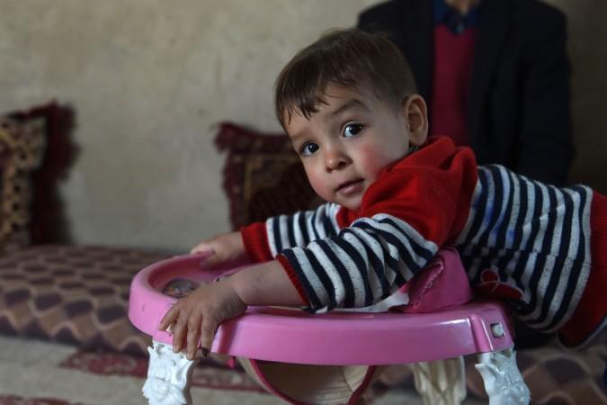 This picture taken on March 16, 2018, shows Afghan father Sayed Assadullah Pooya, 28, posing for a photograph with his son Donald Trump, aged around 18 months, at their home in Kabul. Father named son after Donald Trump in Afghanistan