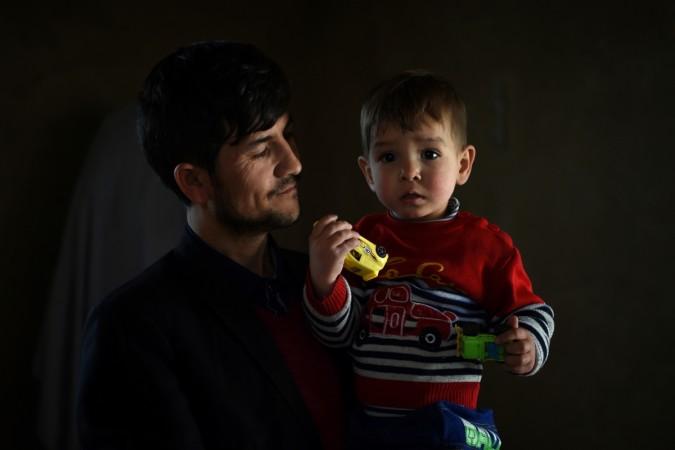 This picture taken on March 16, 2018 shows Afghan father Sayed Assadullah Pooya, 28, posing for a photograph with his son Donald Trump, aged around 18 months, at their home in Kabul. Father named son after Donald Trump in Afghanistan