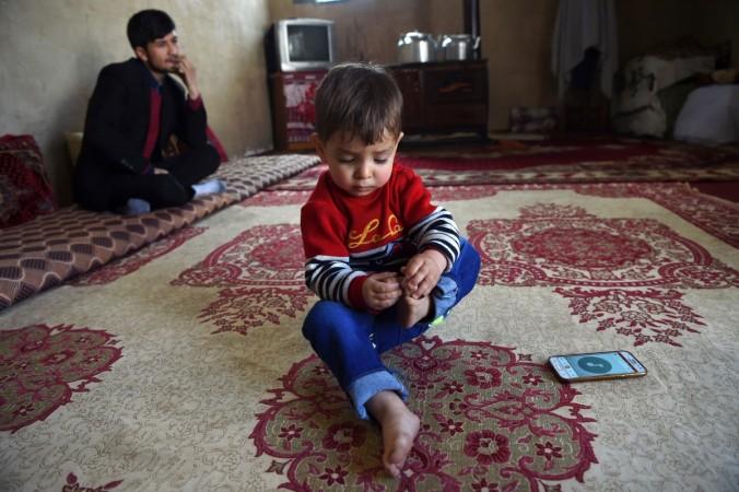 This picture was taken on March 16, 2018 shows Afghan father Sayed Assadullah Pooya, 28, looking on alongside his son Donald Trump, aged around 18 months, during an interview with AFP at their home in Kabul Father named son after Donald Trump in Afghanistan