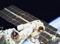 STS088-702-024 -- Astronauts Jerry L. Ross (left) and James H. Newman, both mission specialists, work together on the final of three space walks of the STS-88 mission. One of the solar panels of the Russian-built Zarya module runs through the frame.