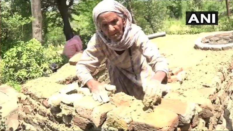 The elderly woman constructed the toilet with her own hands as she cannot afford masons. building toilet