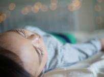 Chinese boy sleeps on window ledge