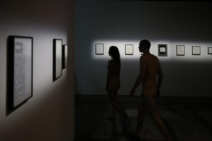 People take part in a nudist visit of the 'Discorde, Fille de la Nuit' season exhibition at the Palais de Tokyo museum in Paris on May 5, 2018 Paris museum opens doors for naked visitors