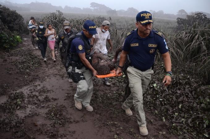 Police officers carry a wounded man after the eruption of the Fuego Volcano, in El Rodeo village, Escuintla department, 35 km south of Guatemala City on June 3, 2018 Guatemala volcano