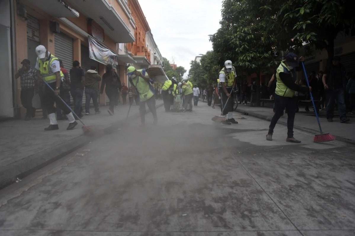Municipal employees sweep up ash after the eruption of the Fuego Volcano, in Guatemala City, on June 3, 2018 Guatemala volcano