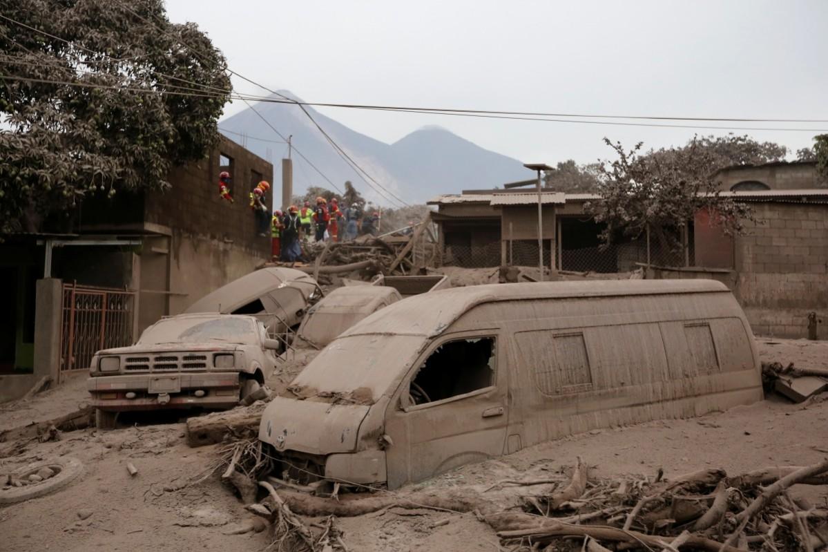 Firefighters and rescue workers look for bodies and survivors at an area affected by the eruption of the Fuego volcano in the community of San Miguel Los Lotes in Escuintla, Guatemala, June 4, 2018 Guatemala volcano