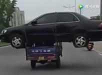 Man ties car on the top of his tricycle